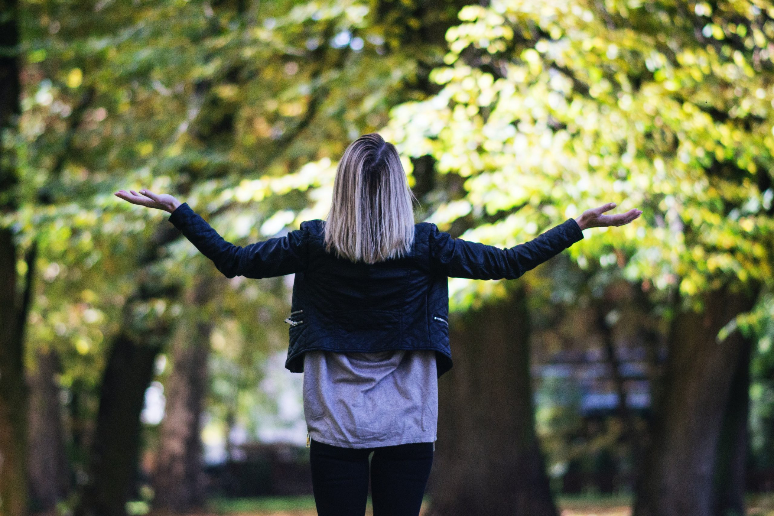 Woman holding up arms to the sky asking why do bad things happen to good people